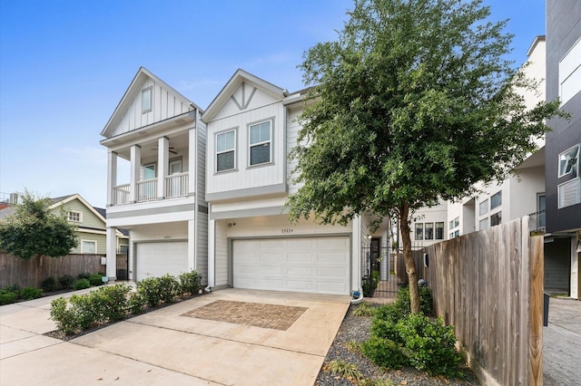 multi unit property with fence, board and batten siding, an attached garage, and a balcony