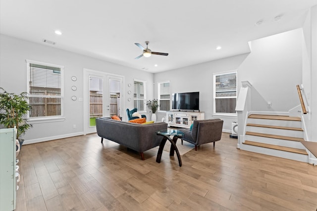 living room featuring a ceiling fan, stairs, wood finished floors, and visible vents