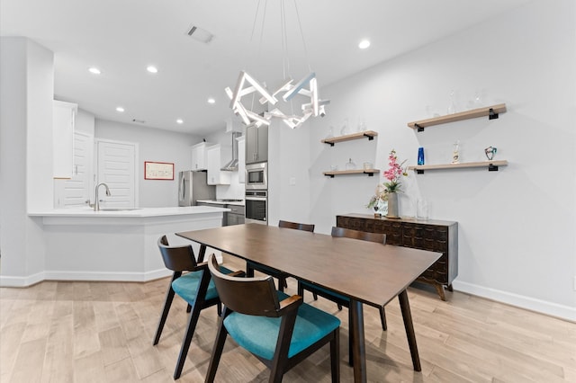 dining space featuring visible vents, light wood-type flooring, baseboards, an inviting chandelier, and recessed lighting