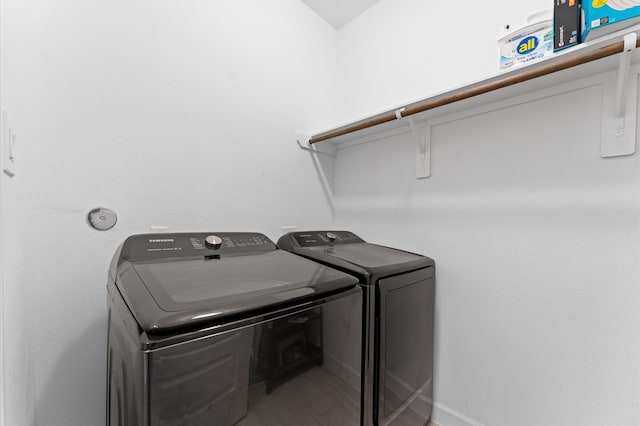 clothes washing area featuring baseboards, laundry area, and washer and dryer