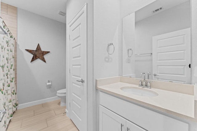 full bathroom featuring vanity, baseboards, toilet, and visible vents