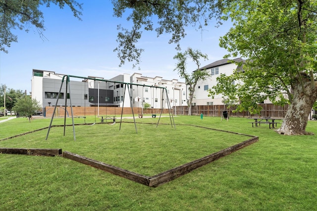 view of property's community with fence, a yard, and playground community