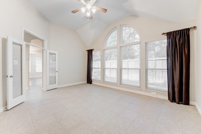 empty room featuring light tile patterned floors, ceiling fan, vaulted ceiling, and french doors