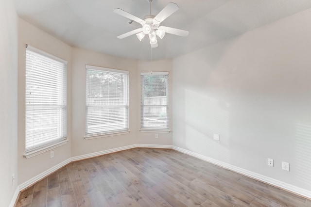 empty room featuring baseboards, ceiling fan, and wood finished floors