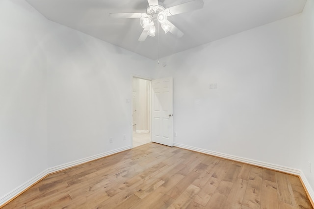 empty room with baseboards, a ceiling fan, and light wood-style flooring
