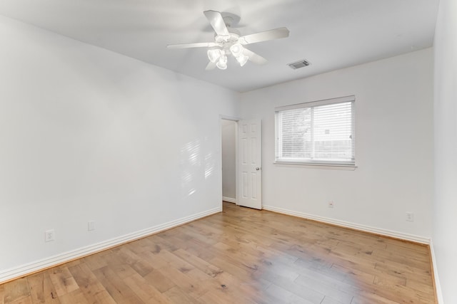 unfurnished room with baseboards, ceiling fan, wood finished floors, and visible vents