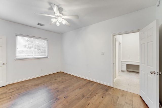 unfurnished bedroom featuring visible vents, a ceiling fan, light wood finished floors, and baseboards
