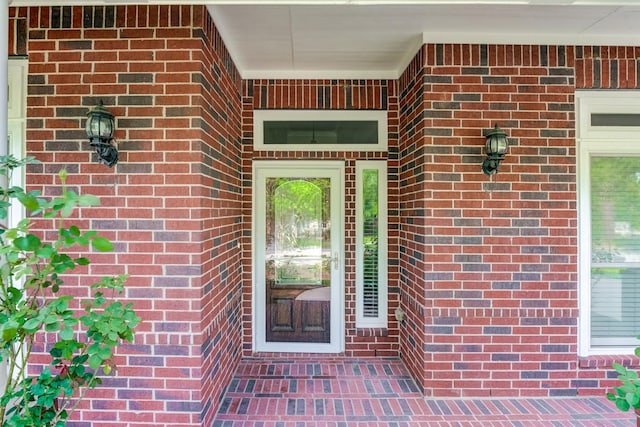 view of exterior entry with brick siding