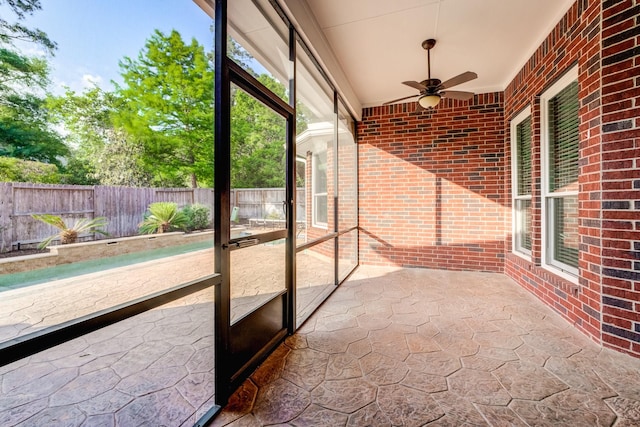 unfurnished sunroom with a ceiling fan