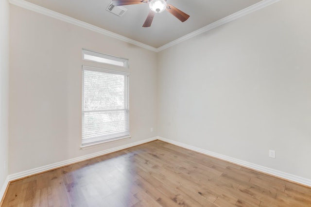 spare room featuring a ceiling fan, baseboards, light wood-type flooring, visible vents, and ornamental molding