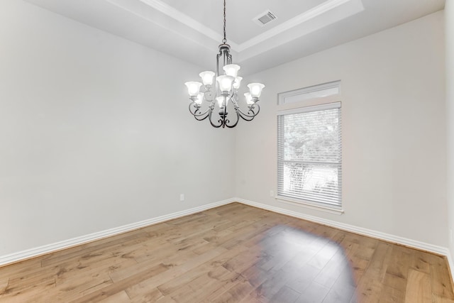 empty room featuring baseboards, a tray ceiling, visible vents, and an inviting chandelier
