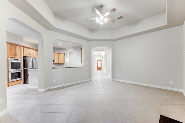 unfurnished living room featuring ceiling fan, visible vents, and light tile patterned floors