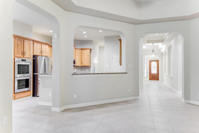 interior space featuring light tile patterned floors, appliances with stainless steel finishes, a tray ceiling, and recessed lighting