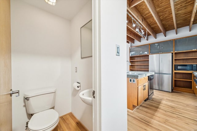 bathroom with a sink, wood finished floors, and toilet