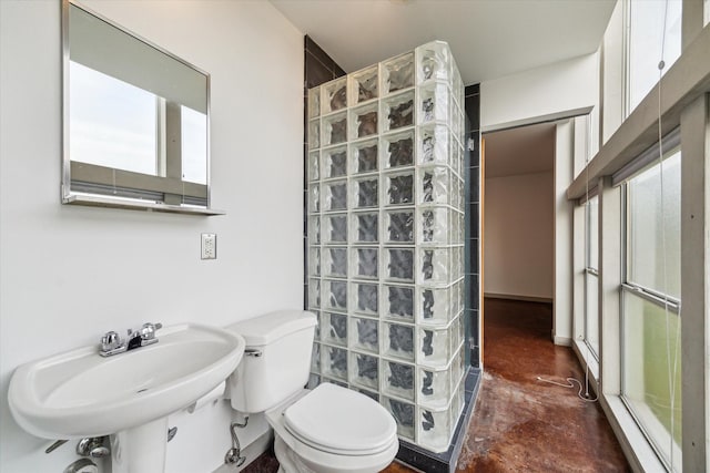 bathroom featuring a sink, concrete floors, walk in shower, and toilet