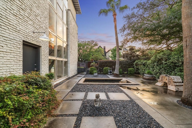 yard at dusk with a patio area and fence