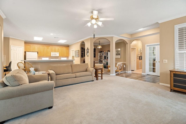 2220 W Marsala Dr, Pearland, TX 77581 - carpeted living area with crown molding, arched walkways, baseboards, and a ceiling fan