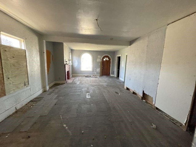 interior space with baseboards and arched walkways