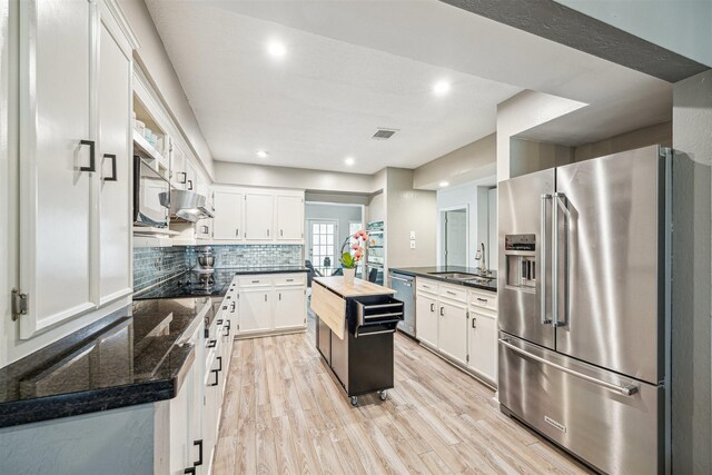 14123 Hillvale Dr, Houston, TX 77077 - kitchen with white cabinets, a sink, stainless steel appliances, decorative backsplash, and visible vents
