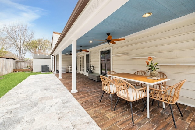 14123 Hillvale Dr, Houston, TX 77077 - view of patio / terrace with ceiling fan, fence, a storage unit, an outbuilding, and outdoor dining space