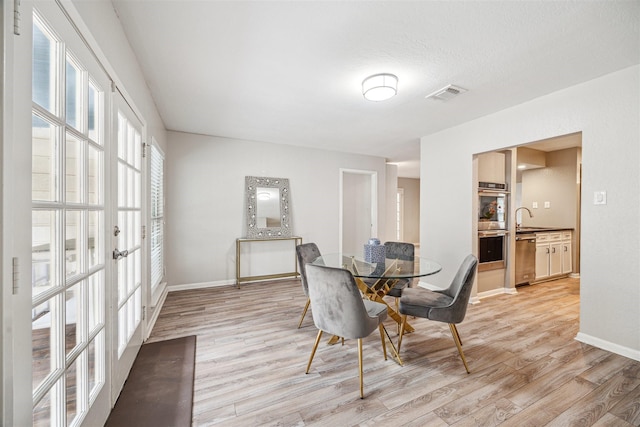 14123 Hillvale Dr, Houston, TX 77077 - dining space featuring baseboards, french doors, light wood-style flooring, and visible vents