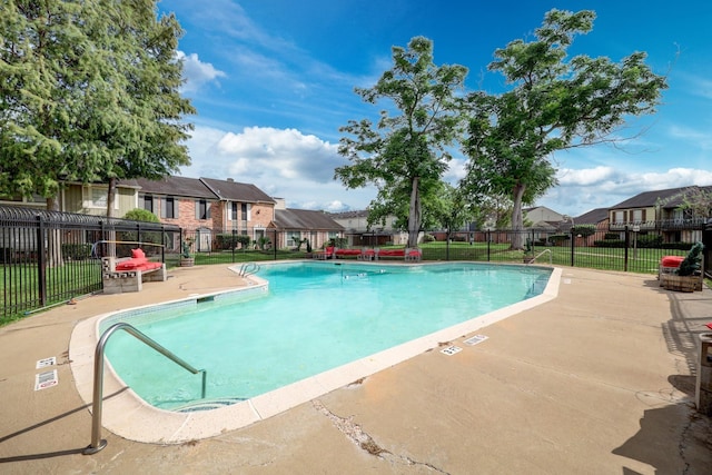 pool featuring a patio area, fence, a yard, and a residential view