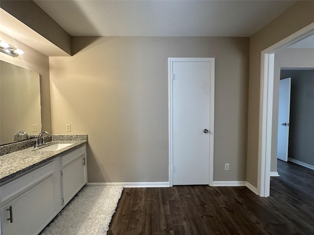 bathroom featuring baseboards, wood finished floors, and vanity