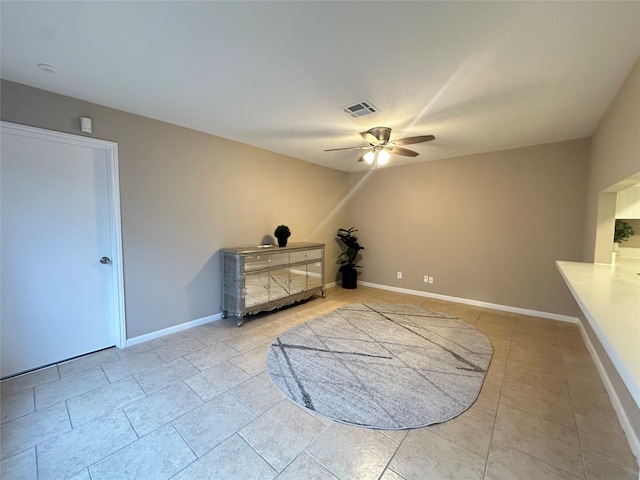 interior space with tile patterned floors, baseboards, a ceiling fan, and visible vents