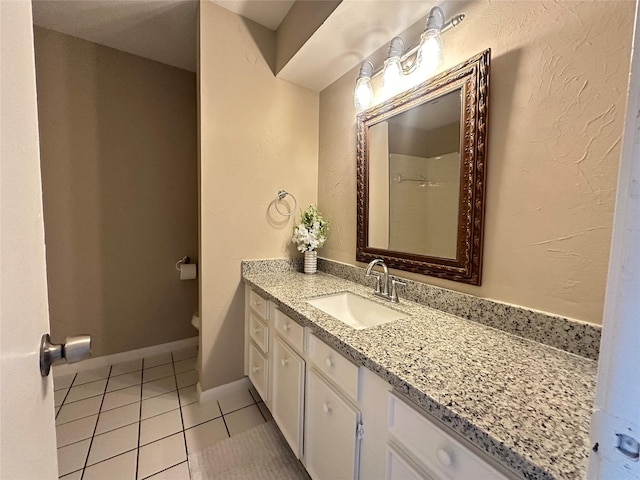 bathroom with toilet, tile patterned floors, and vanity