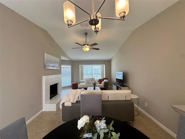10627 Sandpiper Dr Unit 136, Houston, TX 77096 - dining space with vaulted ceiling, light tile patterned floors, a fireplace, ceiling fan, and baseboards