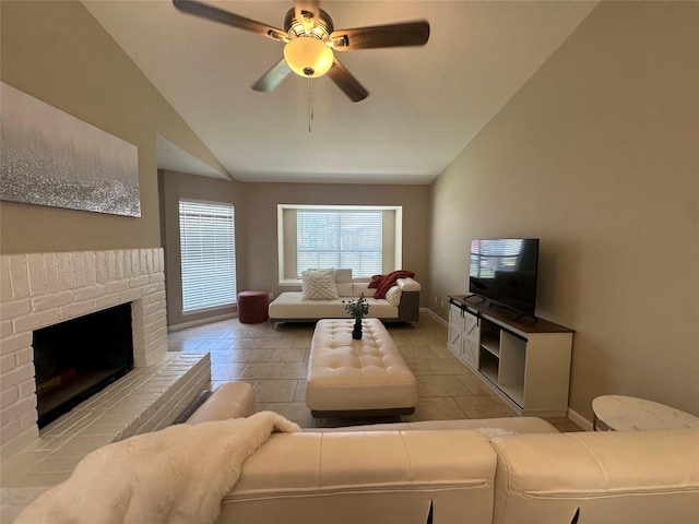 living area with baseboards, a ceiling fan, vaulted ceiling, and a fireplace