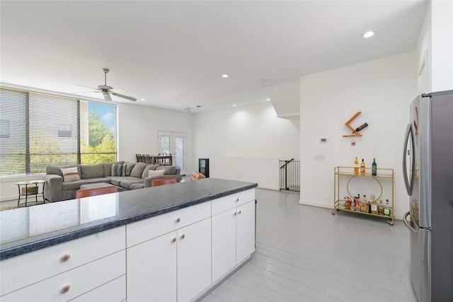 kitchen featuring freestanding refrigerator, a ceiling fan, white cabinetry, open floor plan, and recessed lighting
