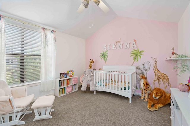 bedroom with vaulted ceiling, carpet flooring, a crib, and a ceiling fan