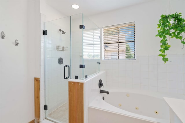 full bathroom featuring a tub with jets and a shower stall