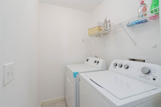 laundry area with independent washer and dryer, light tile patterned floors, and baseboards