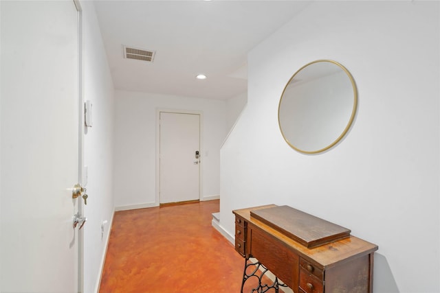 hall featuring finished concrete flooring, recessed lighting, and baseboards