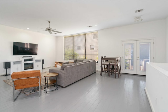 living area featuring french doors, ceiling fan, recessed lighting, light wood finished floors, and baseboards