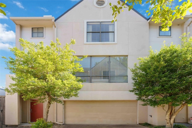 view of front of property featuring an attached garage, stucco siding, and driveway