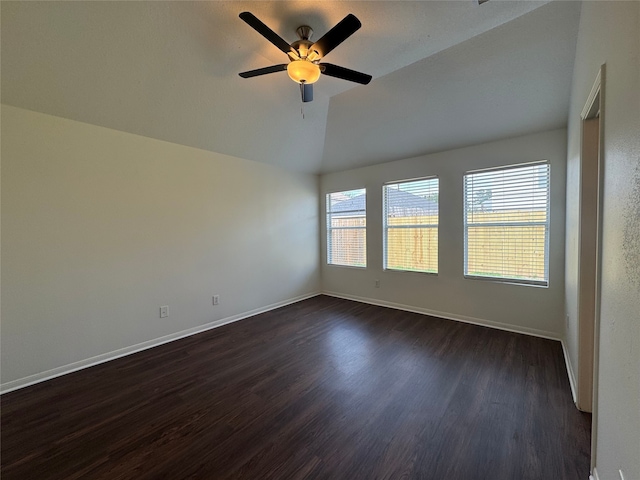 unfurnished room featuring dark wood-style flooring, baseboards, vaulted ceiling, and ceiling fan