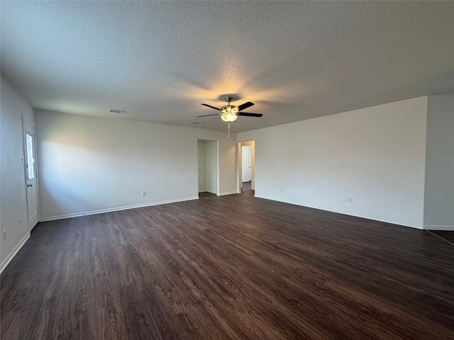spare room featuring a textured ceiling, a ceiling fan, baseboards, dark wood-type flooring, and visible vents