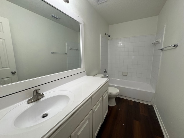 bathroom featuring visible vents, wood finished floors, vanity, toilet, and  shower combination