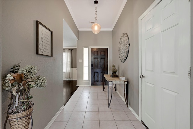 entryway featuring crown molding, baseboards, light tile patterned floors, and visible vents