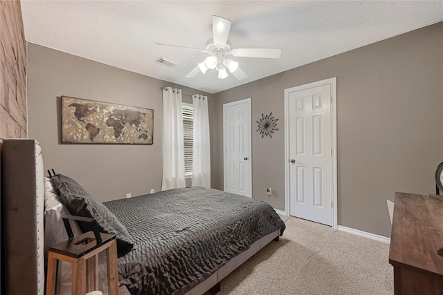 carpeted bedroom featuring baseboards, ceiling fan, two closets, and visible vents