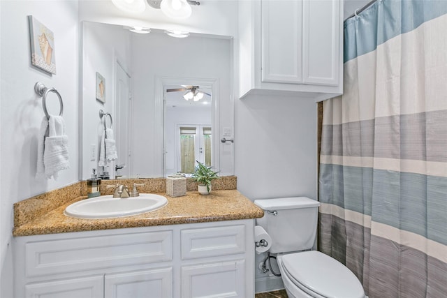 bathroom with vanity, a ceiling fan, a shower with shower curtain, and toilet