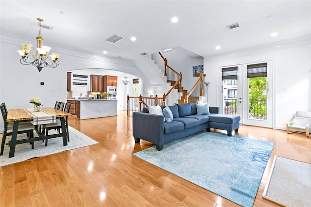 living area featuring arched walkways, a chandelier, stairs, recessed lighting, and visible vents