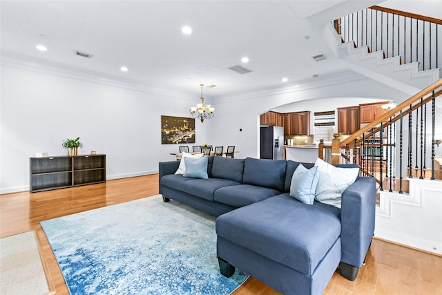 living area with arched walkways, a notable chandelier, stairs, and visible vents