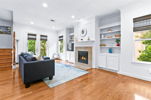 living room featuring ornamental molding, a fireplace, recessed lighting, and visible vents