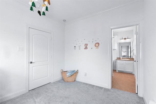 bedroom with baseboards, ornamental molding, ensuite bathroom, and light colored carpet