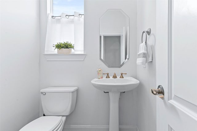 half bath with toilet and baseboards