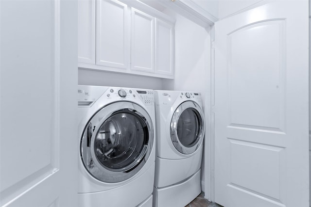laundry area with separate washer and dryer and cabinet space